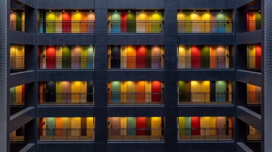 Rows of colourful closed apartment doors lit up